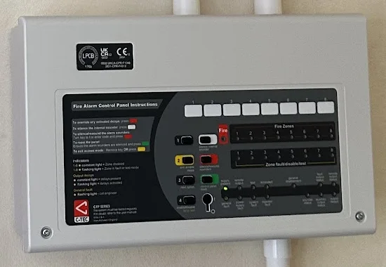 Close-up of a C-TEC fire alarm control panel showing zone lights