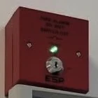 A red fire alarm interface unit with a key switch