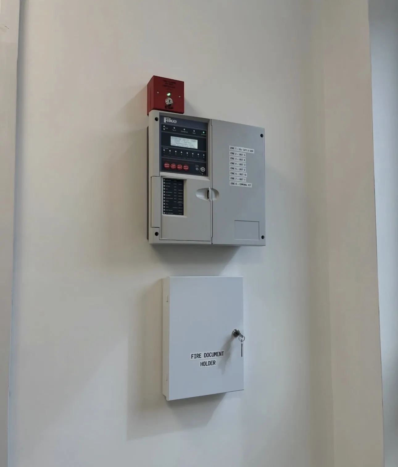 Fike fire alarm control panel with zone labels and fire document holder